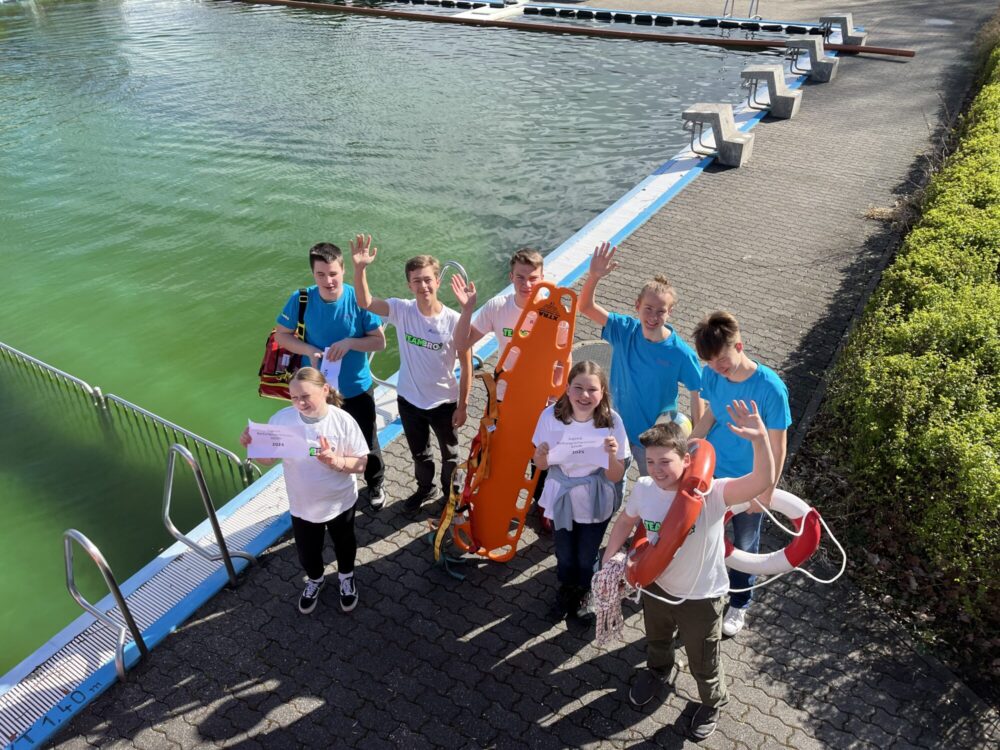 Gruppenfoto der Jugendrettungsschwimmer neben dem Schwimmbecken im Romanusbad.