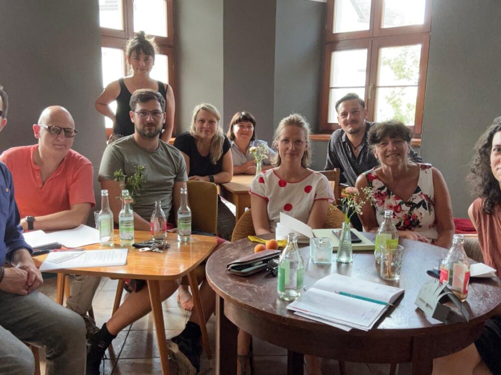 Gruppenfoto einer Sitzung der Ehrenamtlichen in einem Cafe