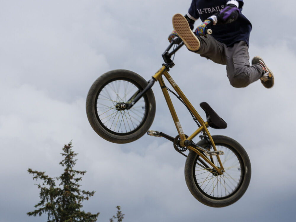 Ein Junge macht einen Tricksprung mit dem BMX-Fahrrad.