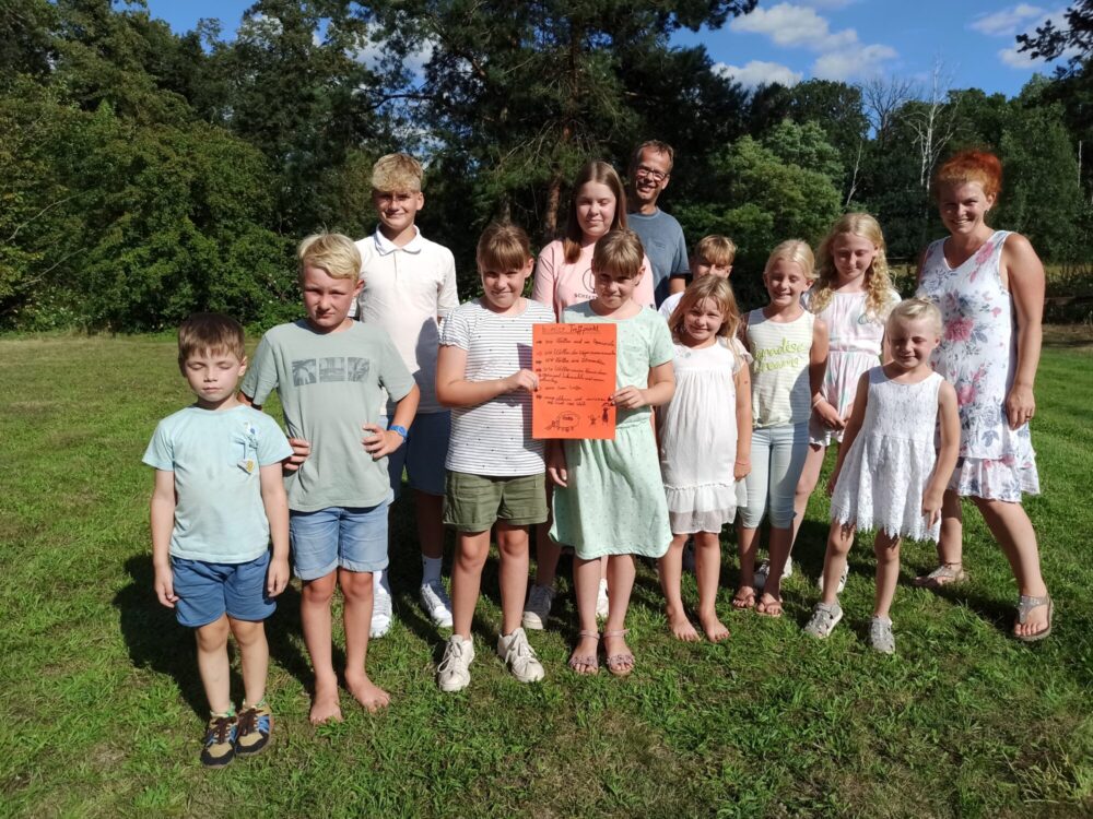 Gruppenfoto von Kindern auf einer Wiese.