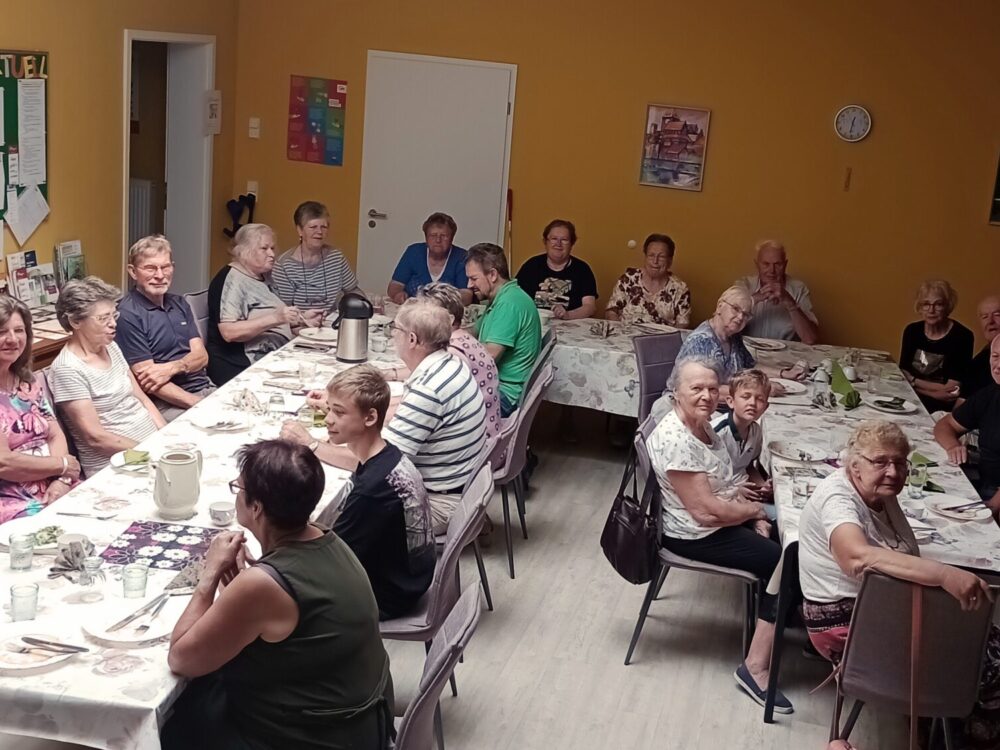 Seniorinnen und Senioren sitzen gemeinsam um einen großen Tisch.